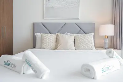 a large white bed with two towels on it at Sunset spot with breathtaking view by Suiteable in Dubai