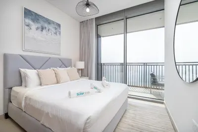 a bedroom with a large white bed and a balcony at Sunset spot with breathtaking view by Suiteable in Dubai