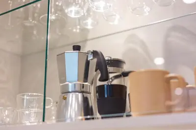 a coffee maker sitting on a counter with glasses at Charming Brand New 2BR close to the Beach in Dubai