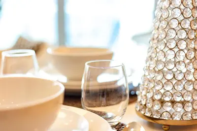 a table with two wine glasses and a vase at Charming Brand New 2BR close to the Beach in Dubai