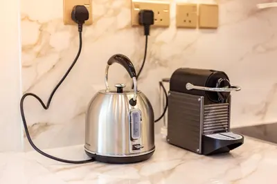 a tea kettle on a counter next to a toaster at Charming Brand New 2BR close to the Beach in Dubai