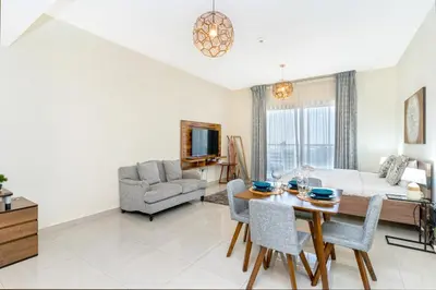 a living room with a table and a couch at Elegant Studio in City Center with Balcony in Dubai
