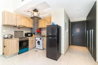 a kitchen with a black refrigerator and a dishwasher at Elegant Studio in City Center with Balcony in Dubai