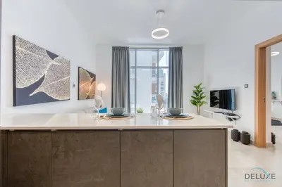 a kitchen with a counter with two plates on it at Upbeat 1BR at Pantheon Elysee Jumeirah Village Circle by Deluxe Holiday Homes in Dubai