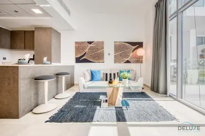 a living room with a couch and a table at Upbeat 1BR at Pantheon Elysee Jumeirah Village Circle by Deluxe Holiday Homes in Dubai