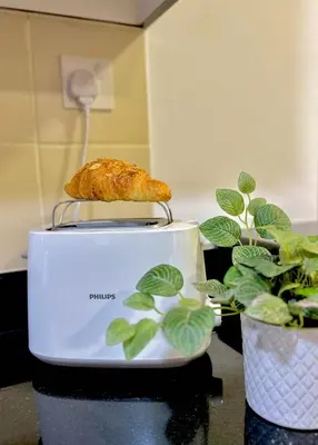 a croissant on a toaster next to a plant at Shams Apart on JBR - 1 Bedroom - Marina View in Dubai