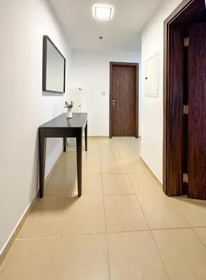 a hallway with a table and a door at Shams Apart on JBR - 1 Bedroom - Marina View in Dubai