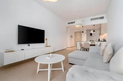 a white living room with a couch and a tv at 1bdr in Belgravia Heights - JVC - Dubai in Dubai