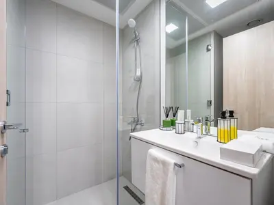 a bathroom with a shower and a sink and a mirror at Superb Studio in Luma 21-JVC in Dubai