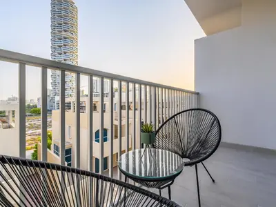 a balcony with a chair and a view of a building at Superb Studio in Luma 21-JVC in Dubai