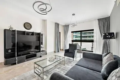 a living room with a couch and a tv at StoneTree - Fairmont North 2 BR - Beach Access in Dubai