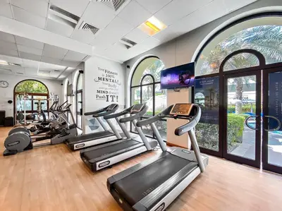 a gym with several treadmills and elliptical machines at StoneTree - Fairmont North 2 BR - Beach Access in Dubai