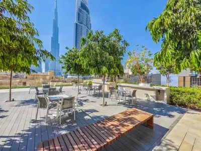 a patio with tables and chairs and trees at Burj Royale Residences Downtown Dubai - Burj Khalifa District in Dubai