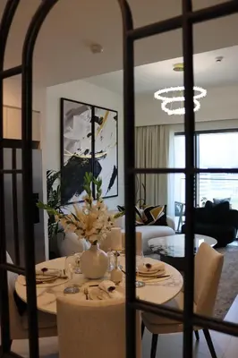 a living room with a table with a vase of flowers at Burj Royale Residences Downtown Dubai - Burj Khalifa District in Dubai