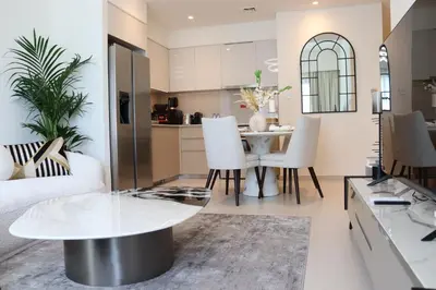 a living room with a table and a kitchen at Burj Royale Residences Downtown Dubai - Burj Khalifa District in Dubai