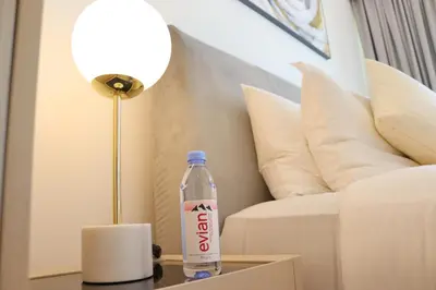 a bottle of coke on a table next to a couch at Burj Royale Residences Downtown Dubai - Burj Khalifa District in Dubai
