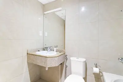 a white bathroom with a sink and a toilet at StoneTree - Marina Crown 1 BR - Dubai Marina in Dubai