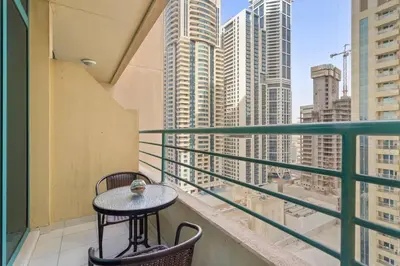 a table on a balcony with a view of a city at StoneTree - Marina Crown 1 BR - Dubai Marina in Dubai