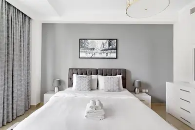 a white bedroom with a bed with towels on it at StoneTree - Marina Crown 1 BR - Dubai Marina in Dubai