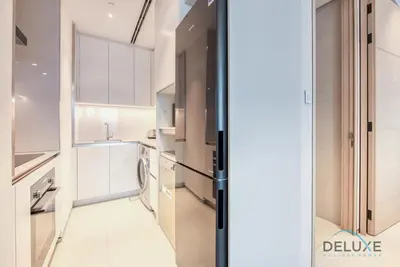 a kitchen with white cabinets and a refrigerator at Stylish 1BR in Prime Location, Book Your Stay by Deluxe Holiday Homes in Dubai