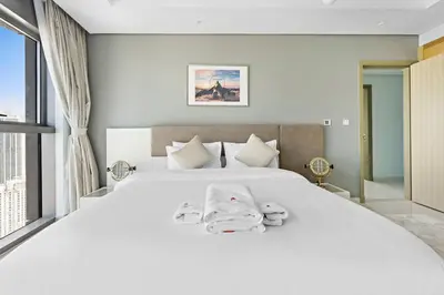 a bedroom with a large white bed with towels on it at StoneTree - Paramount 3 BR - Infinity Pool in Dubai