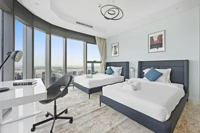 a hotel room with two beds and a desk at StoneTree - Paramount 3 BR - Infinity Pool in Dubai