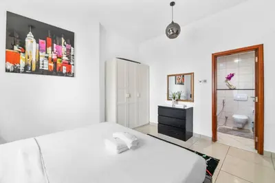 a white bedroom with a bed and a bathroom at StoneTree - Marina Pinnacle 1 BR - Partial Marina View in Dubai