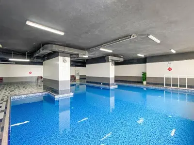 a large swimming pool with blue water in a building at StoneTree - Marina Pinnacle 1 BR - Partial Marina View in Dubai