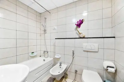 a white bathroom with a sink and a toilet and a tub at StoneTree - Marina Pinnacle 1 BR - Partial Marina View in Dubai