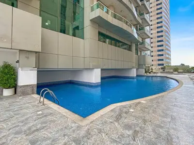 a large building with a swimming pool in front of a building at StoneTree - Marina Pinnacle 1 BR - Partial Marina View in Dubai
