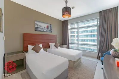 a hotel room with two beds and a window at Alashrafia Saray- Central 2BR apartment in Downtown in Dubai
