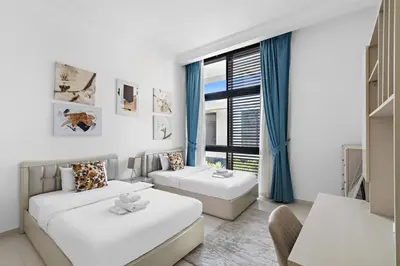 a white room with two beds and a window at StoneTree - Pelham Villa 3 BR - Damac Hills in Dubai