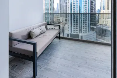 a couch on a balcony with a view of a city at MAG 318 Studio Walk to Dubai Mall in Dubai