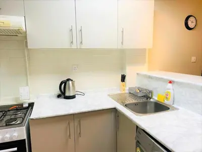 a kitchen with white cabinets and a sink and a stove at Royal Manor- Marina Diamond 2 in Dubai