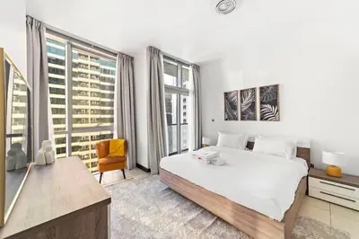 a bedroom with a large white bed and large windows at StoneTree - Indigo Tower 1BR - Panoramic View in Dubai