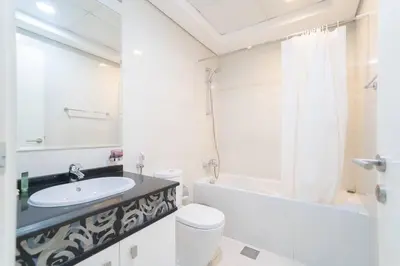 a white bathroom with a sink and a toilet at StoneTree - Elegant Studio in Business Bay in Dubai