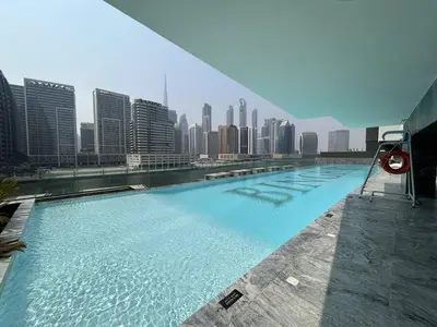 a large swimming pool with a city skyline in the background at Trophy Amazing Burj Khalifa Views from This Stylish Condo in Dubai