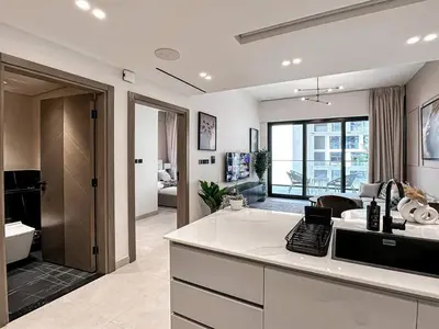 a kitchen with a counter and a living room at Trophy Amazing Burj Khalifa Views from This Stylish Condo in Dubai