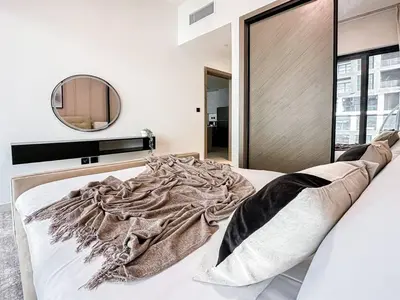 a bedroom with a large bed with a mirror at Trophy Amazing Burj Khalifa Views from This Stylish Condo in Dubai