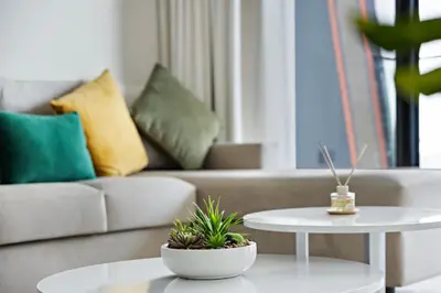 a living room with a couch and two tables with plants at WelHome - Contemporary 1BR in Binghatti Canal & Burj Views in Dubai