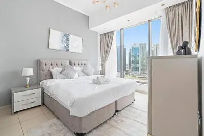a bedroom with a large bed and a large window at StoneTree - Modern 1BR near Dubai Marina Mall in Dubai