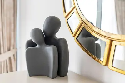 a statue of two people next to a mirror at StoneTree - Modern 1BR near Dubai Marina Mall in Dubai