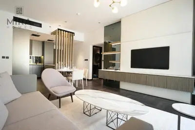a living room with a couch and a tv at Mira Holiday Homes - Newly 1 bedroom with pool access in Dubai