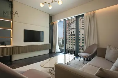 a living room with a couch and a tv at Mira Holiday Homes - Newly 1 bedroom with pool access in Dubai