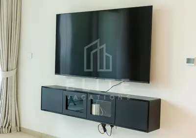 a flat screen tv on top of a black entertainment center at Walk to Dubai Mall 2 Bed Full Burj Khalifa Views in Dubai
