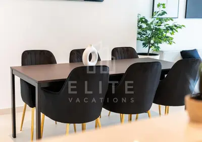 a dining room table with black chairs around it at Walk to Dubai Mall 2 Bed Full Burj Khalifa Views in Dubai