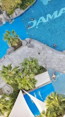 an overhead view of a swimming pool with palm trees at Luxury Paramount Hotel Apt D111 in Dubai