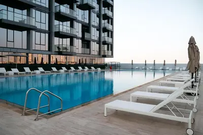 a swimming pool with lounge chairs and a building at Luxurious & Modern Studio in JVC in Dubai