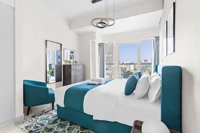a bedroom with a large bed and a large window at StoneTree - Damac Heights 1BR apartment in Dubai