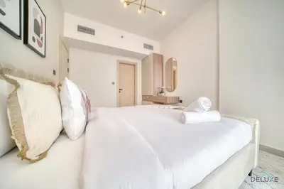 a white bedroom with a large white bed with pillows at Timeless 1BR at Binghatti Avenue Al Jaddaf by Deluxe Holiday Homes in Dubai